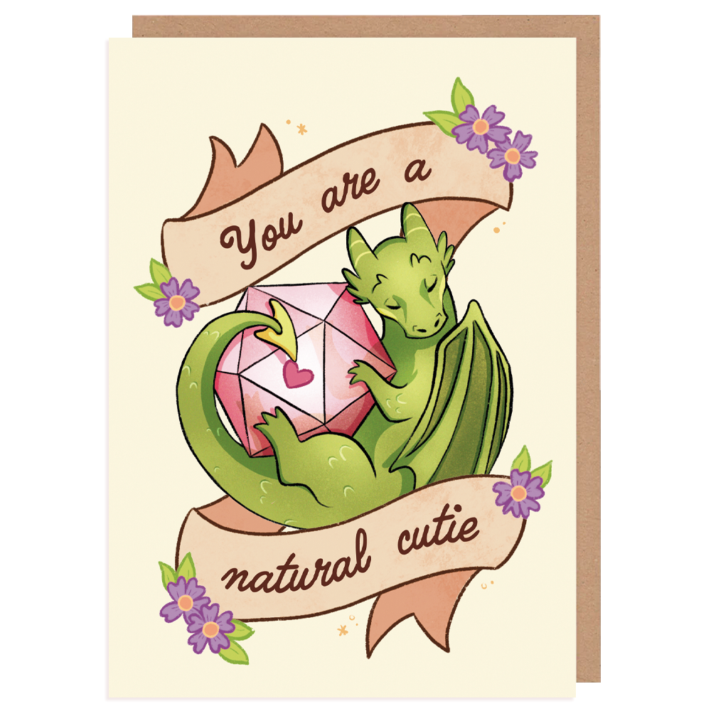 A product mockup of a D&D themed A6 postcard. It pictures a dragon with a D20 dice and text saying ''you are a natural cutie''